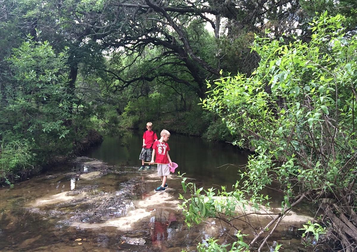 Two children playing in a river.